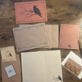 Correspondence Corner — Autumn 2026, flat lay with raven postcard, seasonal writing sheets, envelopes, archive card, wax seals, and pen.